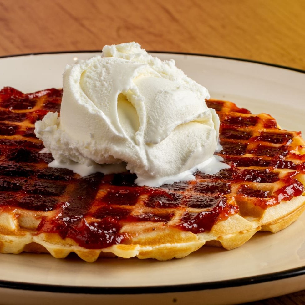 Nosso delicioso waffle com geleia de morango e sorvete. O sorvete é enviado separadamente.
