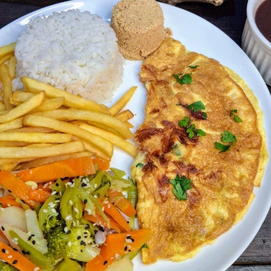 Experimente nossa saborosa omelete com queijo muçarela e cebolinha de folha. Acompanha arroz, feijão fresquinho, farofa de bacon, maionese ou legumes. Escolha entre, batata frita, aipim frito ou salada.