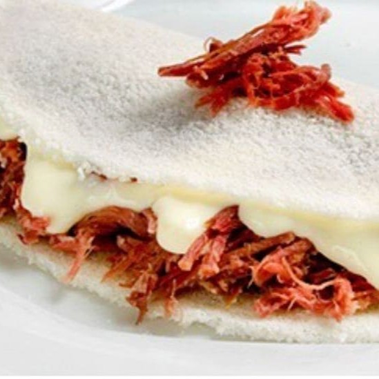 Uma explosão de sabores tipicamente nordestinos!  Recheada com carne seca desfiada e temperada, mussarela derretida, tomate fresco, cebola , alho torrado e um leve toque de orégano. Finalizada com manteiga de garrafa, que realça os sabores e traz ainda mais autenticidade ao prato. Uma experiência completa para o paladar.