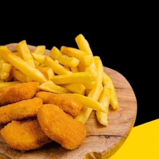 Este prato, nomeado 'Nugget com batata frita e farofa', pertence à categoria 'Para quem ama frango'. A descrição vibrante é a seguinte: 'Deliciosamente composto por nuggets de frango irresistíveis, preparados com carinho e crocância perfeita. Acompanha batatas fritas, douradas e crocantes, e a nossa especialidade, a farofa da casa, que agrega um toque caseiro e único. Para completar, não poderíamos deixar de lado o tradicional arroz e feijão, preparados no ponto certo e com um sabor inconfundível. Este prato é o equilíbrio perfeito entre sabor e textura, ideal para os amantes de frango.'