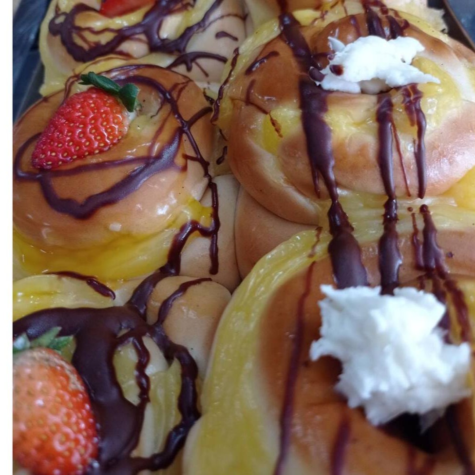 Pão doce caracol, ou nó   Obs: imagem ilustrativa.  Possui diversas confeitarias por cima.