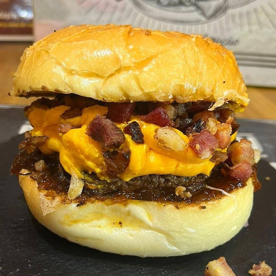 Pão australiano,hamburguer de carne bovina,cheddar melt da casa,bacon e molho verde.