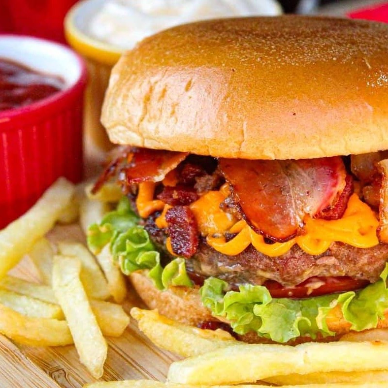 Pão de brioche , 130 g de brioche da Maju, bastante cheddar, fatias de bacon super crocantes, alface, tomate e molho