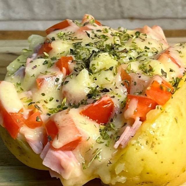 Batata Recheada Super Bauru, feita com bastante queijo mussarela, presunto, tomate picado, Catupiry e orégano por cima para finalizar essa delicia.