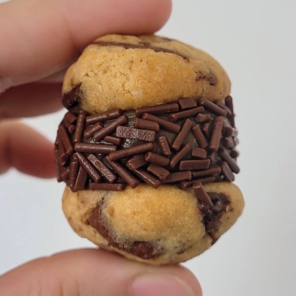 Nosso sensacional cookie artesanal de baunilha com gotas de chocolate, recheio de brigadeiro ao leite cremoso  Aproximadamente 30g