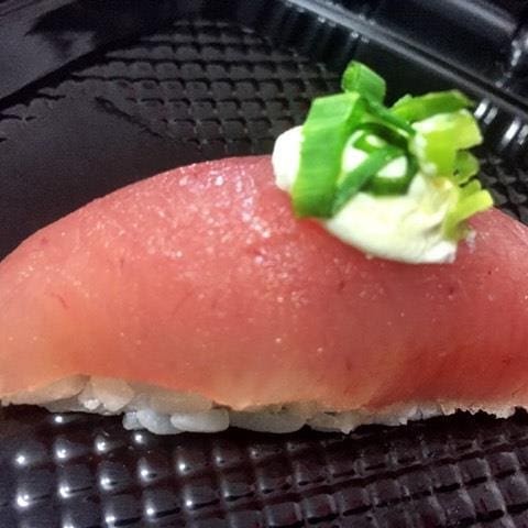 Sushi Atum fresco com cream cheese em cima com cebolinha.