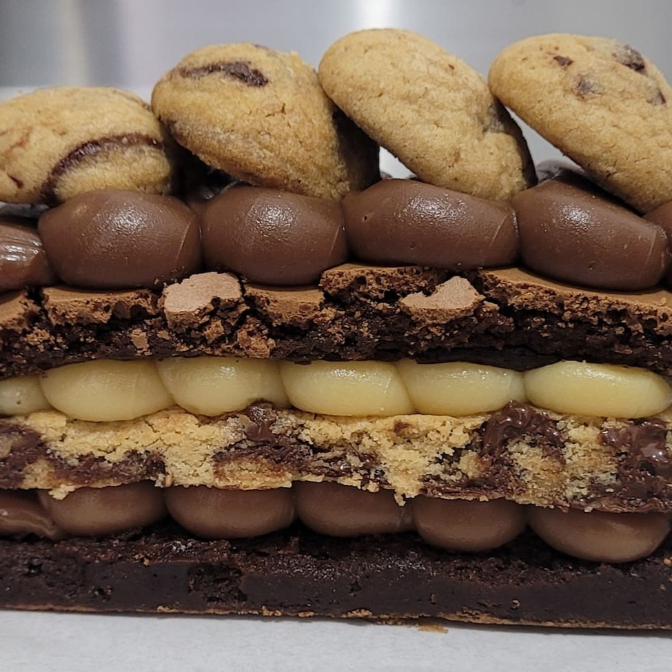 A fatia perfeita existe e você só encontra aqui  2 camadas do nosso brownie chocolatudo  1 camada de cookie Recheios e cobertura de brigadeiro Topo com vários maravilhosos mini cookies  Aproximadamente 250g