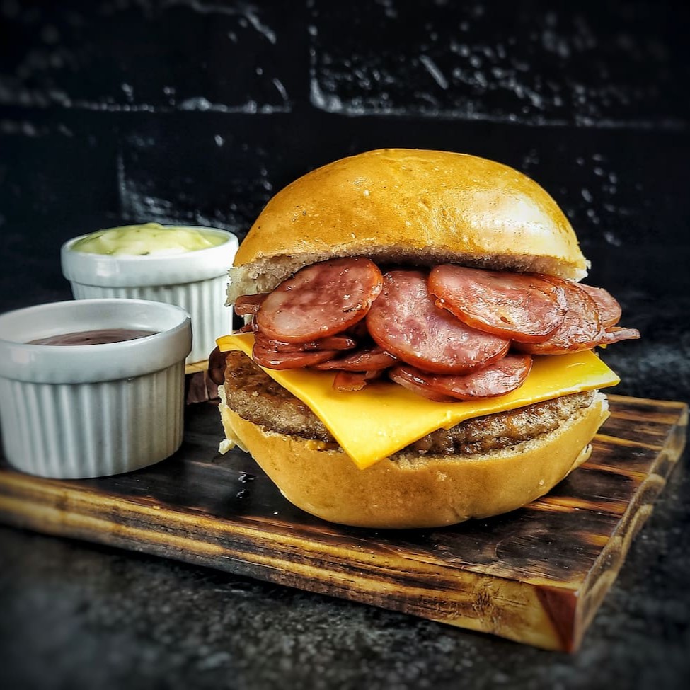 O 'Russo Calabresa' é um dos nossos ' Sanduíches americano'. Esta maravilha gastronômica é construída com um pão bola fresco e macio, recheado com uma generosa porção de carne suculenta. Acrescentamos a ela uma fatia de queijo cheddar derretido de alta qualidade e um delicioso e crocante embutido de calabresa. Para dar um toque de especial, adicionamos nosso exclusivo e secreto molho da casa juntamente com o ketchup.  O 'Russo  Calabresa' é uma verdadeira explosão de sabores em cada mordida!