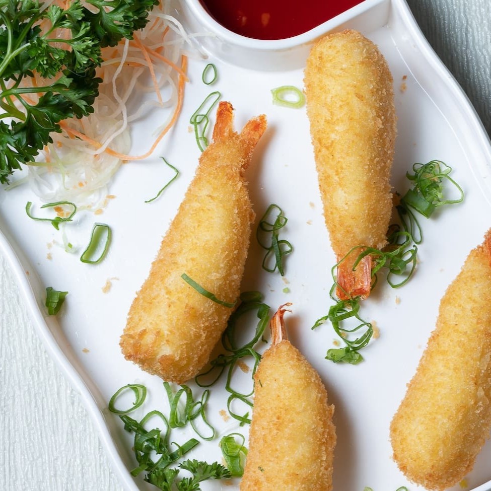 Deliciosa porção de 4 camarões empanados recheados com cream cheese.  Acompanha: 1 molho