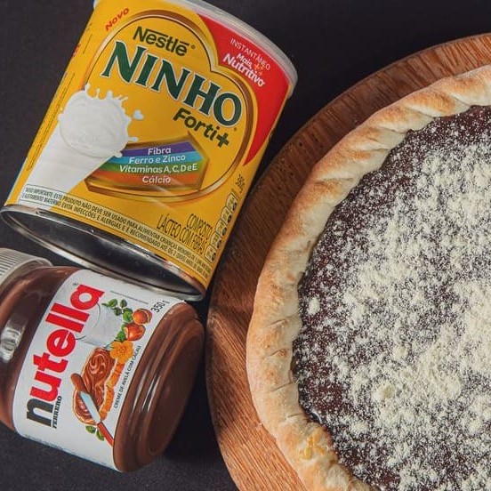 Essa Pizza Despensa comentários. Com uma camada Generosa de Nutella Jamais visto. Você experimenta a melhor pizza doce da Terra. Com  Creme de Leite, camada Generosa de Nutella e Leite Ninho (tudo Original). Brotão (25cm)