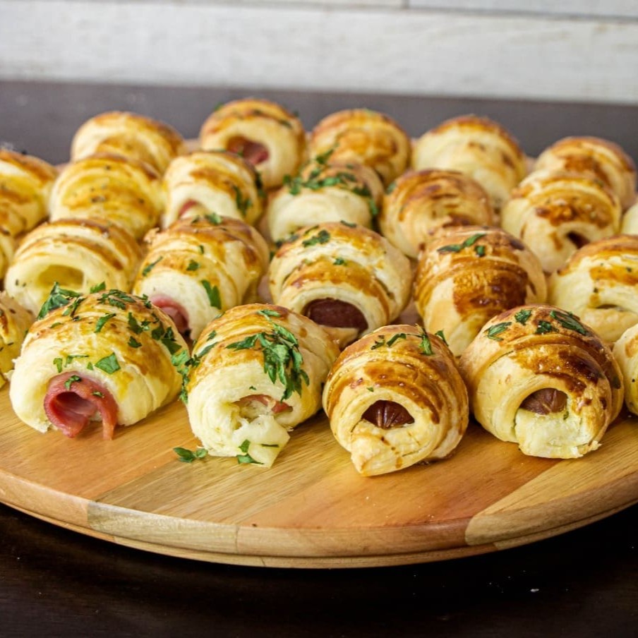 Delicinha de verdade! Massa folhada leve e amanteigada, recheada com sabores variados pra agradar todos os gostos: queijo com presunto, peito de peru, frango temperado, blanquet, provolone, queijo minas ou salsicha. Peça o seu favorito ou monte um sortido pra sair feliz da vida!