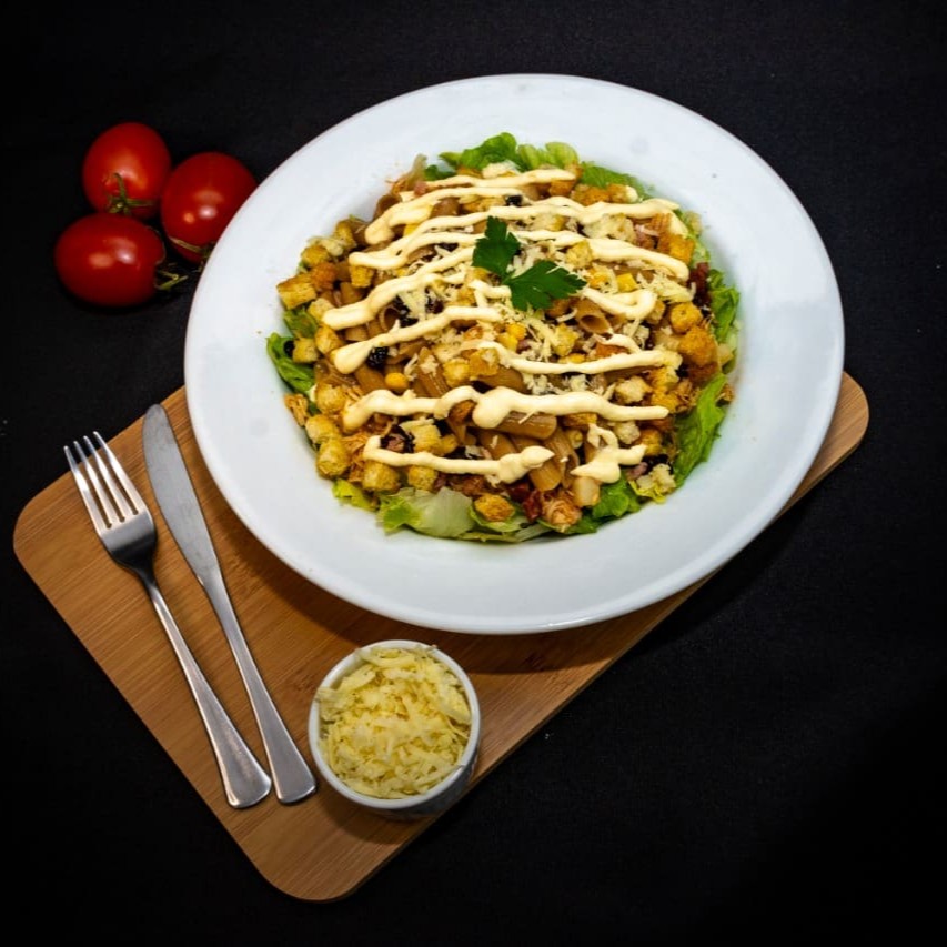 Alface americana, 1/2 porção da massa desejada, molho caesar ou mostarda e mel, croutons, tomate cereja, queijo parmesão e 4 ingredientes de sua escolha