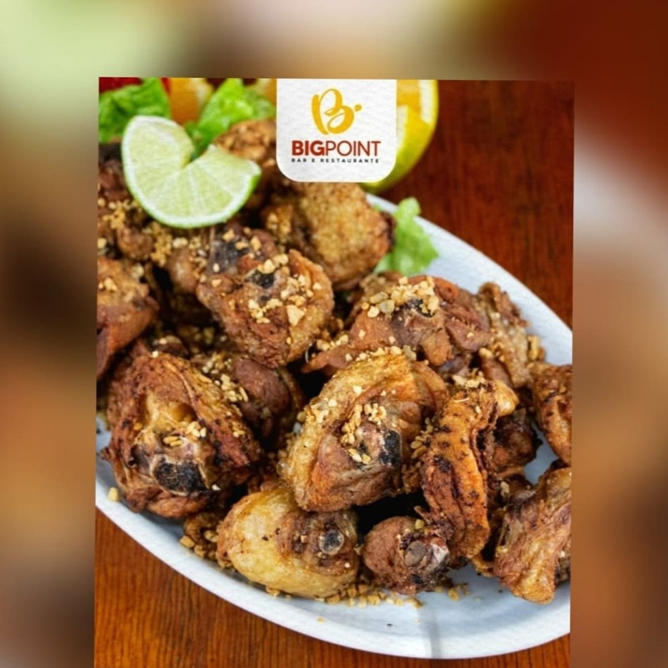 Cortes de frango fritos e servidos com alho torrado.