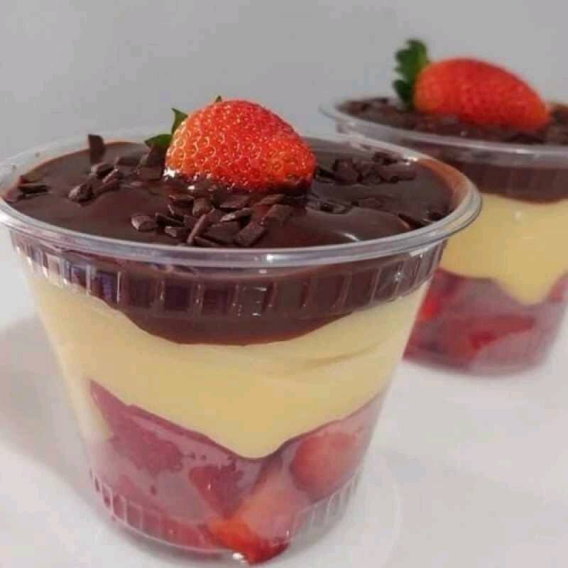 Morangos picados, uma camada de recheio cremoso de ninho e uma camada de recheio cremoso de brigadeiro 50% cacau, finalizado com granulado de chocolate nobre e meio morango.