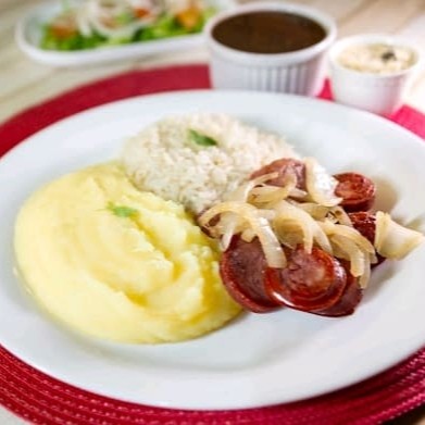 Prato robusto e saboroso, com calabresa acebolada, preparada com cebola caramelizada. Acompanha arroz soltinho, feijão saboroso, farofa crocante com calabresa (em saquinho separado) e mais um acompanhamento à sua escolha.  Nossas refeições são servidas em embalagem de isopor de aproximadamente 700ml.