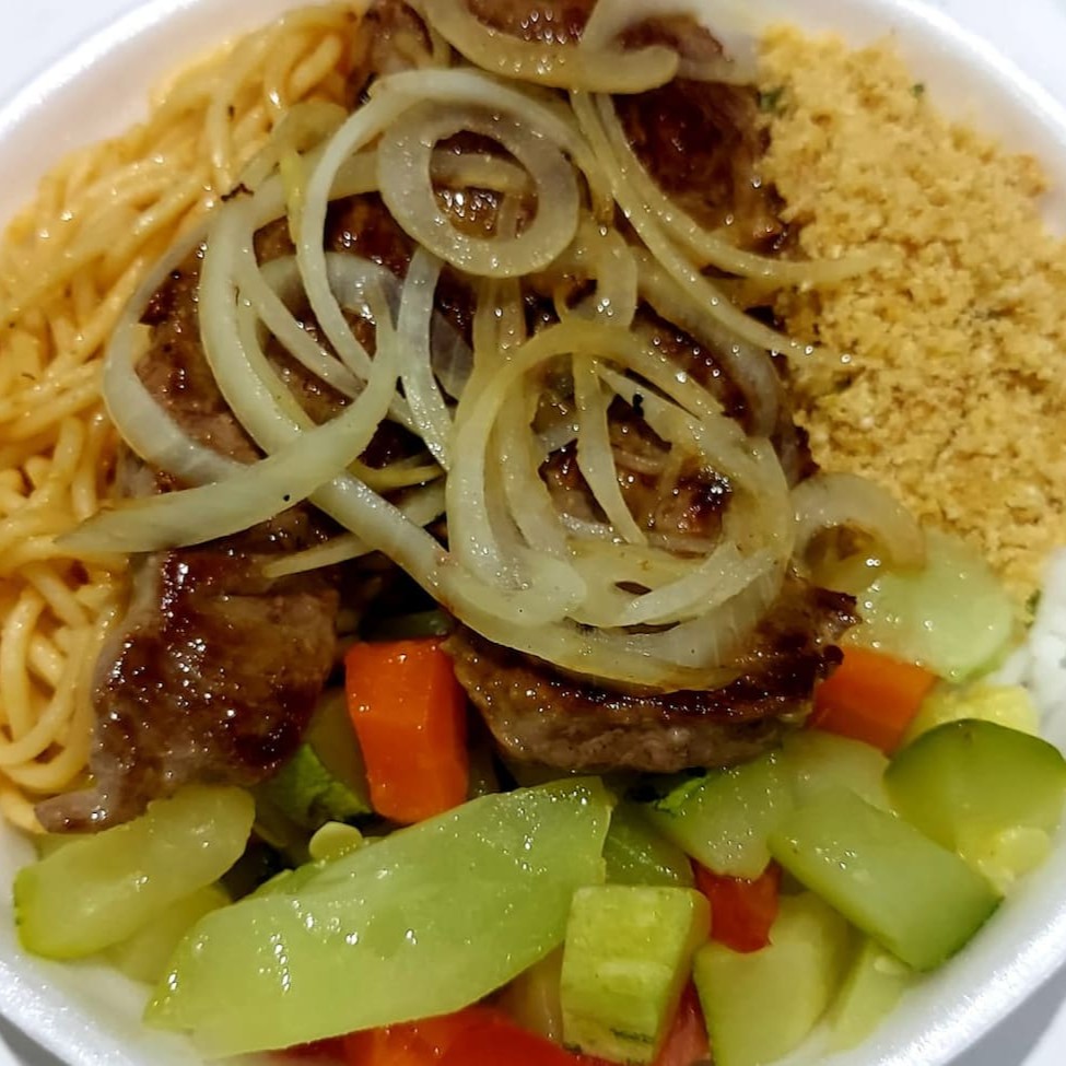 Delicie-se com nosso apetitoso Contrafilé Acebolado, grelhado à perfeição. Esta opção de almoço inclui também uma base clássica da culinária brasileira: arroz soltinho, feijão saboroso, macarrão ao molho e uma farofa crocante. Todas as nossas refeições são servidas com um Guaracrac para completar sua experiência gastronômica. Você ainda tem a opção de escolher um acompanhamento adicional para personalizar sua refeição ao seu gosto. Desfrute deste banquete culinário!