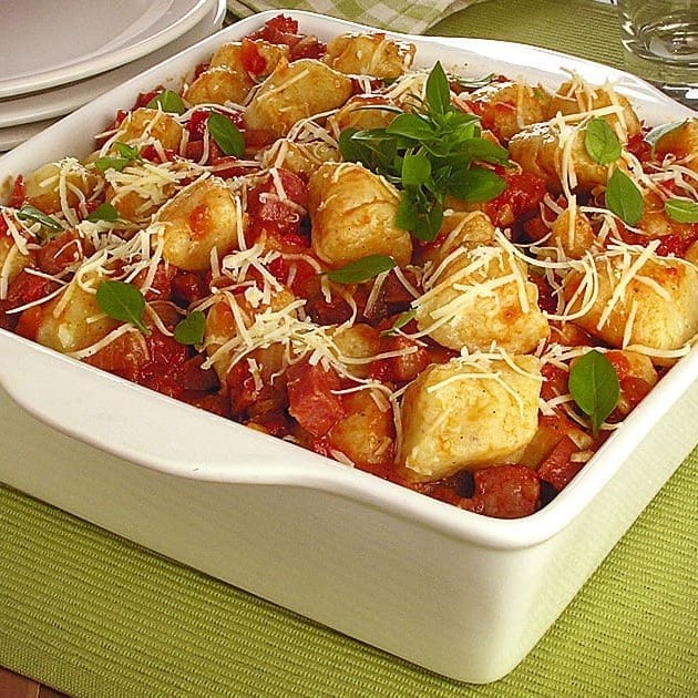 Apresentamos o nosso aclamado 'Gnocchi (Nhoque) com Molho Especial do Chef Bruno'. Este prato é uma combinação magnífica, aprovada e assinada pelo nosso renomado Chef. A suavidade do gnocchi caseiro é realçada pelo nosso robusto molho à bolonhesa de Patinho, recheado com pedaços generosos de bacon e calabresa refogados à perfeição. O prato é finalizado com uma generosa camada de parmesão derretido e catupiri, criando uma sinfonia de sabores inesquecíveis. Disponível em porções de 500g e 800g. Venha experimentar um dos nossos pratos mais vendidos e saboreie a autêntica cozinha italiana!