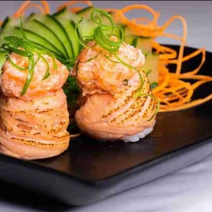 Bolinho de arroz enrolado com neta de salmão e recheado com salmão, todo massaricado