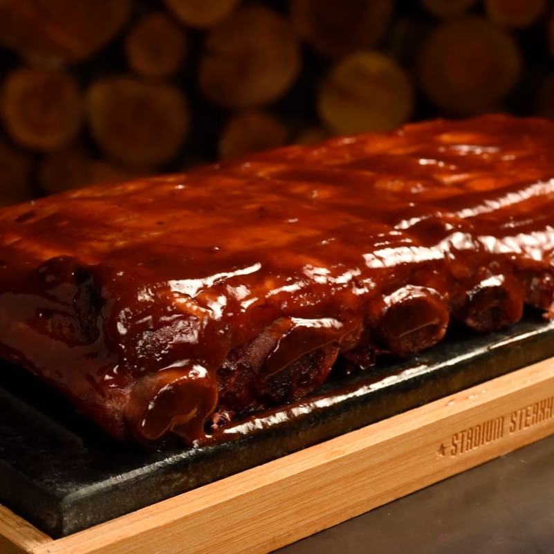 O diferencial sobre a costela preparada na casa, proporciona um sabor muito especial. O preparo ocorre em duas etapas: 1 Defumando a costela durante 3 horas. 2 Cozinhando por 5 horas. Um total de 8 horas de preparo. Produzida Artesanalmente No Nosso Pit Smoker. Servida com 2 acompanhamentos.