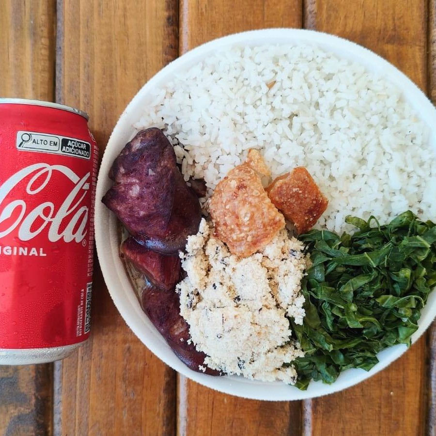 Uma deliciosa quentinha de feijoada completa com arroz branco, couve refogada, farofa da casa e torresmo crocante com uma coca cola lata geladinha. Marmita sugerido para 1 pessoa com 1kg. Quentinha  preparado na hora do seu pedido.