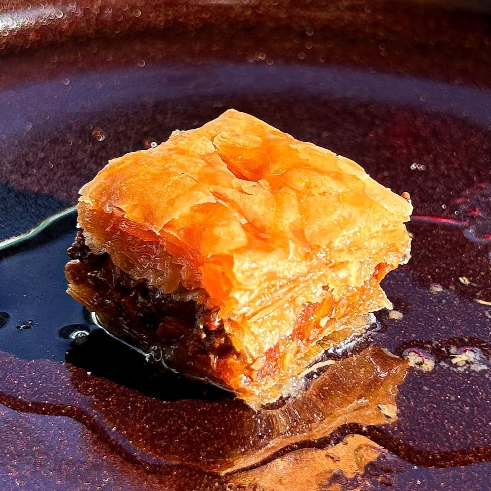 Massa folhada com recheio de castanha de caju e calda de flor de laranjeira. Tamanho médio