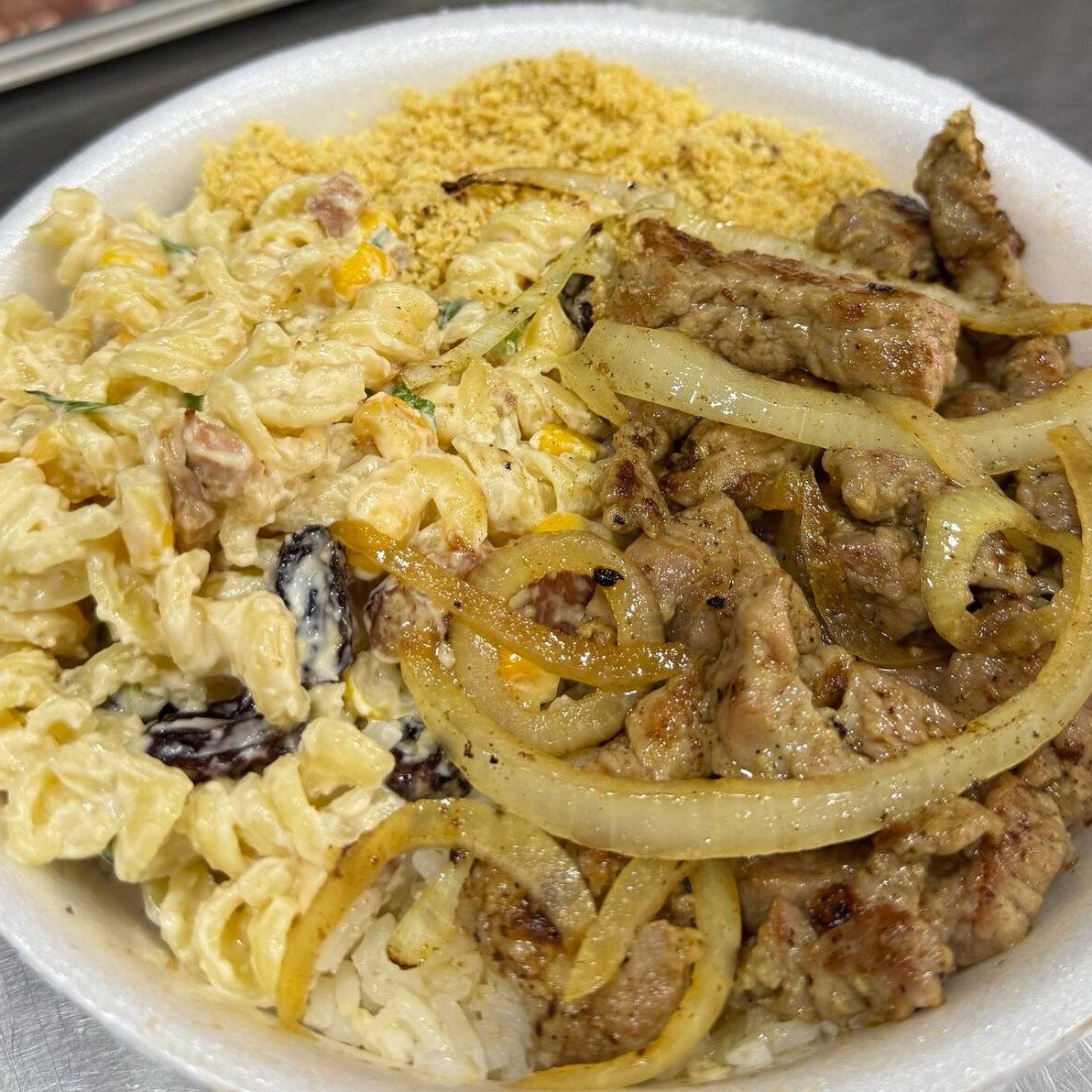 Arroz, feijão, farofa, macarronese e contra filé em tiras acebolado.