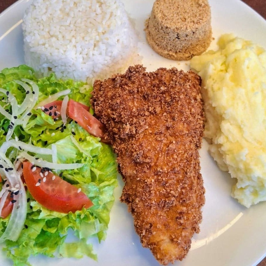 Delicioso filé de Linguado empanado, Acompanha arroz, feijão fresquinho, farofa de bacon e purê de batatas. Escolha entre legumes ou salada verde.
