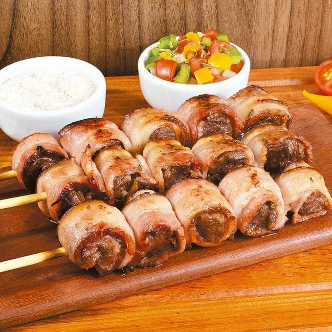 Descubra o sabor irresistível do Medalhão Bovino: um espetinho de carne bovina premium envolto em bacon crocante. Cada pedaço oferece uma combinação perfeita de suculência e sabor defumado, garantindo uma experiência gastronômica única. Ideal para quem aprecia uma refeição gourmet com um toque especial.