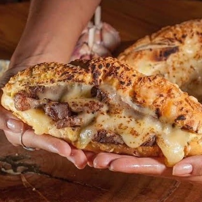 Pão parmesão artesanal,150g costela desfiada,pasta de alho,molho barbecue,cebola roxa,finalizado com queijo mussarela gratinada.
