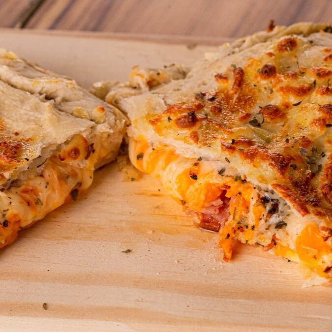 Molho, muçarela, fatias de bacon, cheddar cremoso e orégano