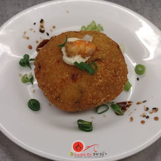 Cookie de arroz, camarão, cebolinha e cream cheese empanado com cobertura de cream cheese e camarão.