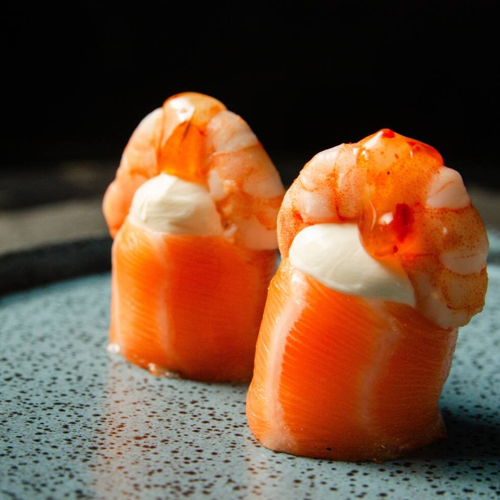 Salmão enrolando arroz com cream cheese, camarão e um toque de pimenta sweet chilli sauce.