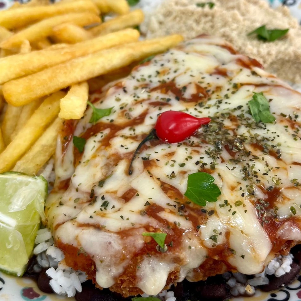 Filé de peixe empanado com molho de tomate caseiro e queijo gratinado com toque de orégano. Acompanha arroz, feijão bem temperado, farofa e batata frita.