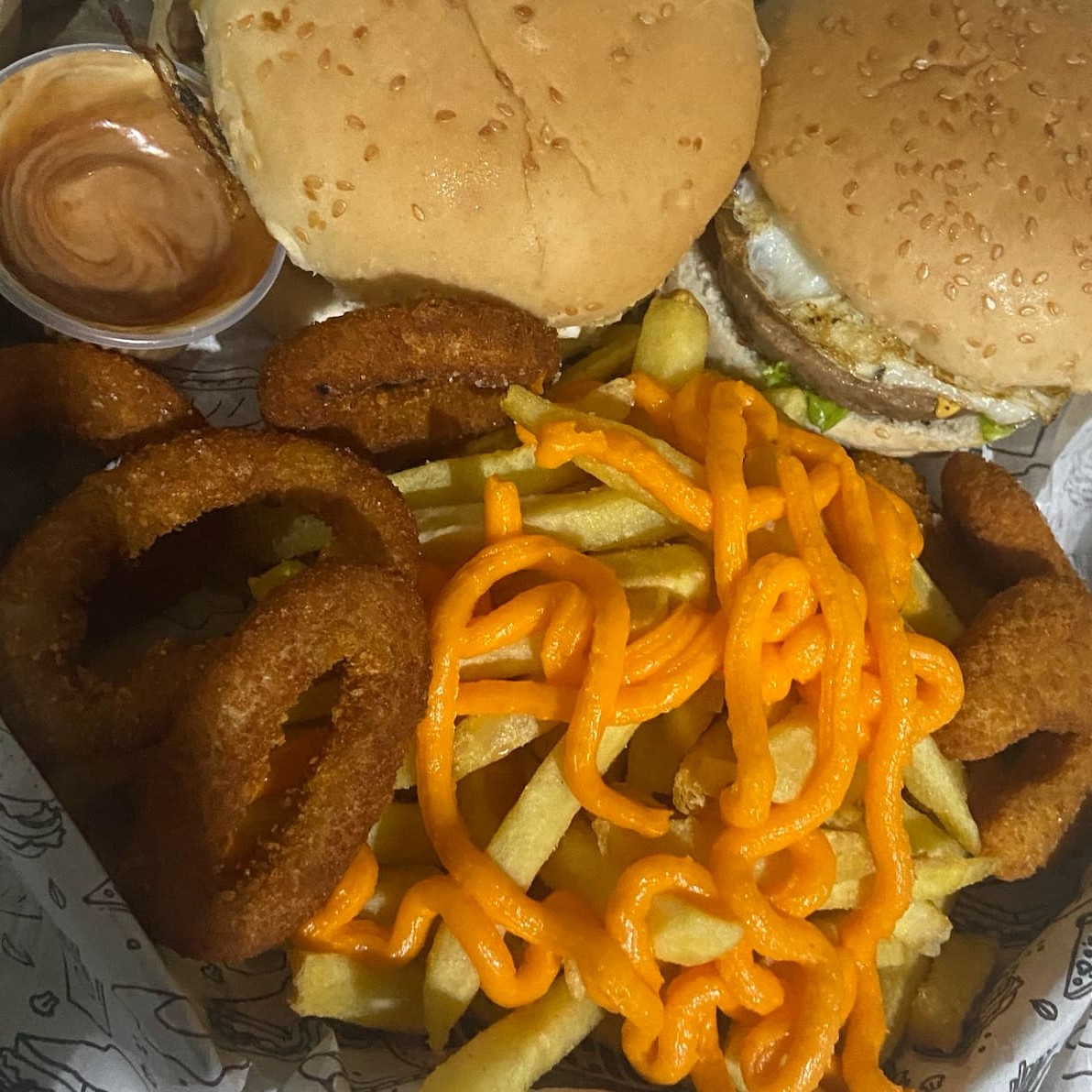 2 x-tudo(Pão, carne, queijo, ovo, queijo ,presunto, bacon, calabresa, alface, molho(maionese, ketchup) batata frita com cheddar, Nuggetes, anel cebola. Caixa 25cm