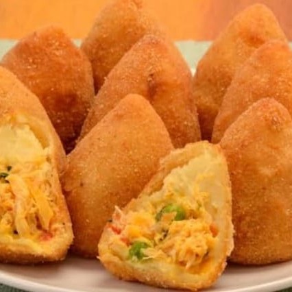 Deliciosas Coxinhas de Frango, embaladas com cuidado em pacote contendo 50 unidades. Cada coxinha é cuidadosamente preparada e recheada com o mais suculento e saboroso frango. São ideais para qualquer ocasião, seja uma festa, um lanche rápido ou apenas para satisfazer aquele desejo de comer algo realmente saboroso. Elas são a combinação perfeita de uma casquinha crocante por fora e um recheio macio e irresistível por dentro. Faça parte do grupo de pessoas que não resistem à tentação de saborear estas coxinhas de frango excepcionais. Pertencem à categoria 'Salgados e Pão de queijo Congelados'. Ideal para quem busca praticidade sem abrir mão do sabor autêntico e caseiro.