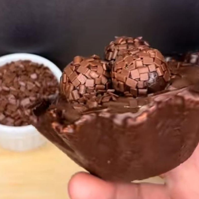 Casquinha de sorvete, banhada de chocolate com recheio de brigadeiro pedaços de brawnei pedaços de chocolate e brigadeiro