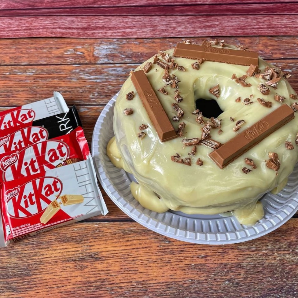 Experimente nossa novidade: o irresistível 'Bolo de Kit Kat'! Uma obra-prima culinária que celebra a combinação perfeita entre a delicada massa branca ou a rica massa de chocolate, com uma generosa cobertura de leite condensado. Para finalizar, o prato é abrilhantado por uma unidade do seu Kit Kat favorito, trazendo um toque crocante que irá surpreender o seu paladar. Um deleite para os amantes de
