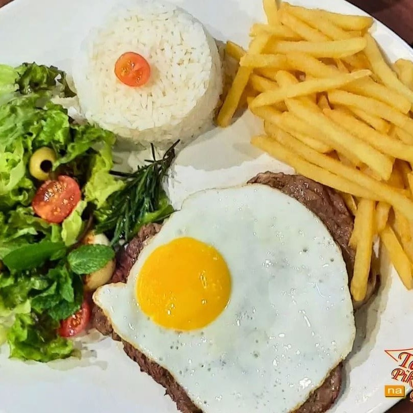 Delicioso '300 - Bife a Cavalo' da categoria 'Mini Refeições'. Contém um arroz soltinho e bem temperado, acompanhado de um feijão caseiro, repleto de sabor. A batata frita, crocante e dourada, é um complemento irresistível. O prato ainda conta com um ovo frito com a gema no ponto certo, proporcionando uma experiência gastronômica única. Para completar, uma salada verde fresquinha, que traz leveza e equilíbrio ao prato. Uma refeição saborosa e completa!