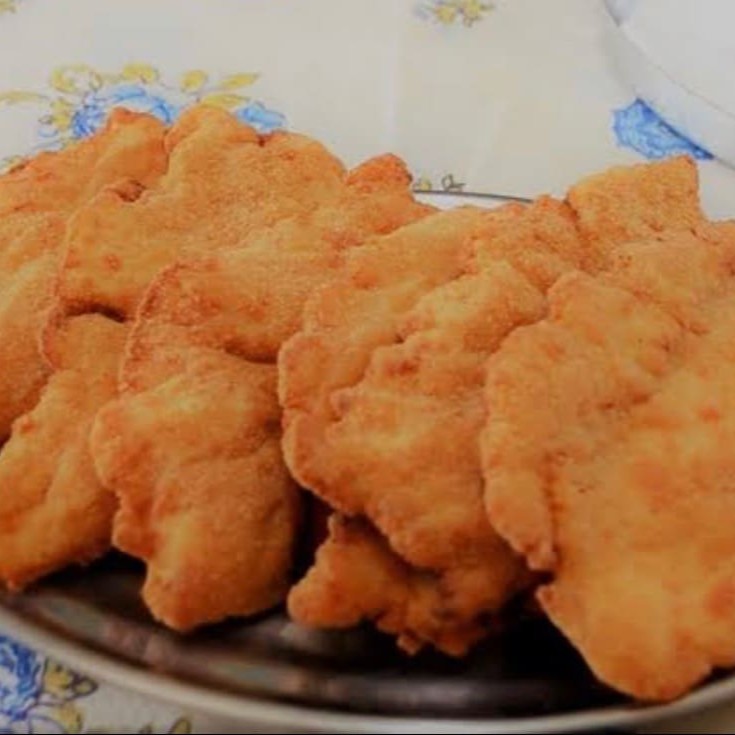 Uma porção de filé de frango á milanesa acompanhado de uma porção de arroz , uma porção de batata frita , molho e farofa.