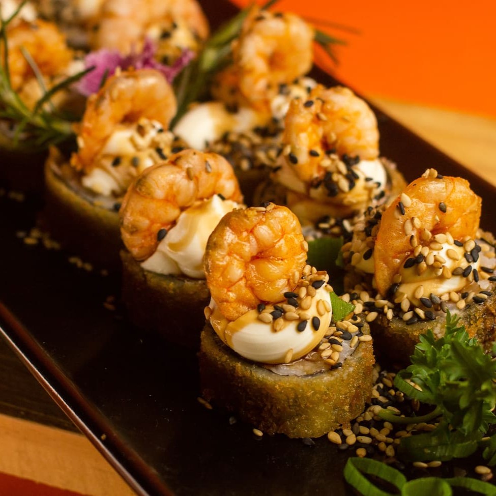 """Porção com 12 unidades de Hot Ebi, sushi empanado e crocante por fora, recheado com camarão fresco e suculento, combinado com cream cheese cremoso que derrete na boca a cada mordida. Preparado com arroz temperado na medida certa, oferece uma explosão de sabores e texturas, perfeita para compartilhar ou saborear sozinho."""