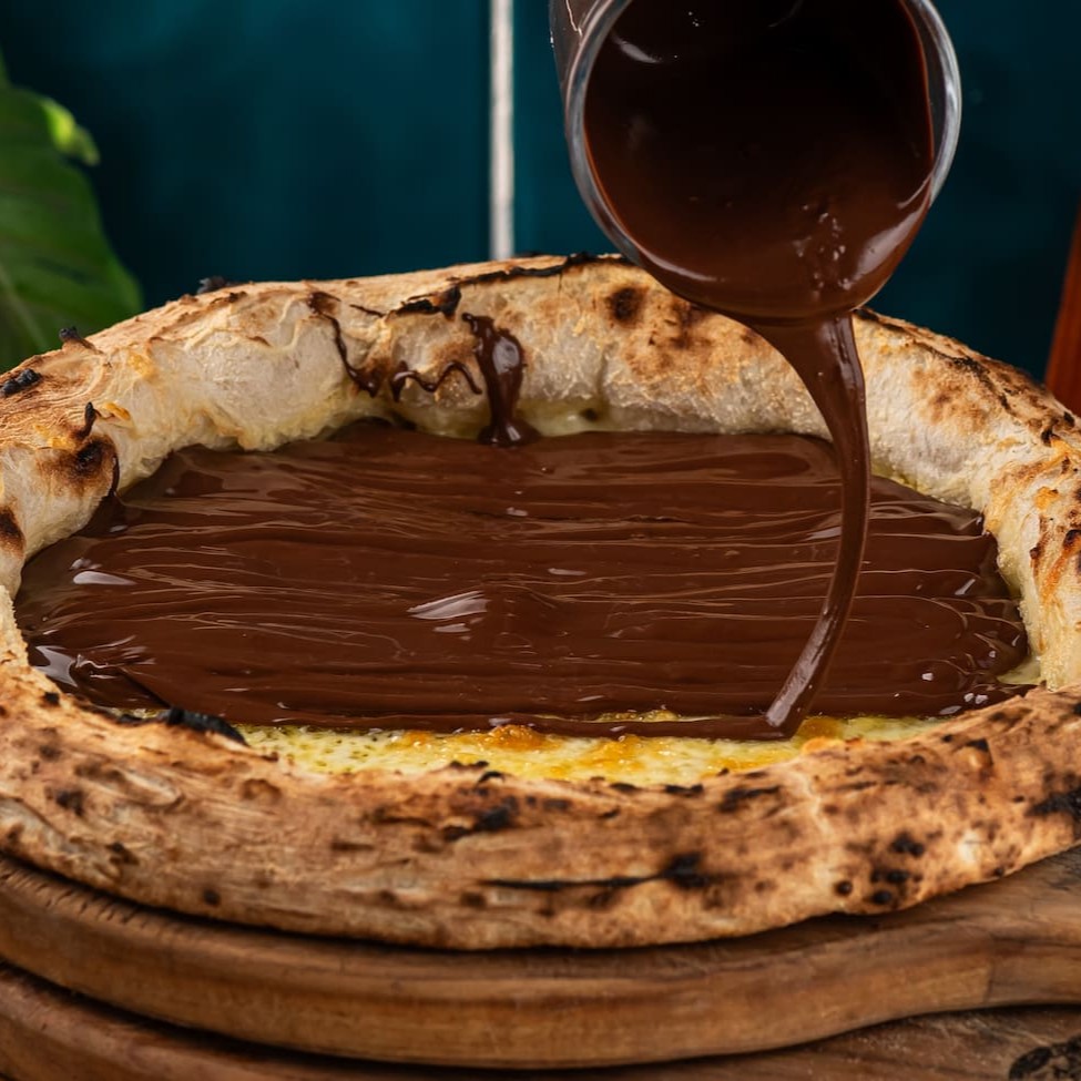 Massa em fermentação natural, mozzarella e calda de chocolate artesanal.
