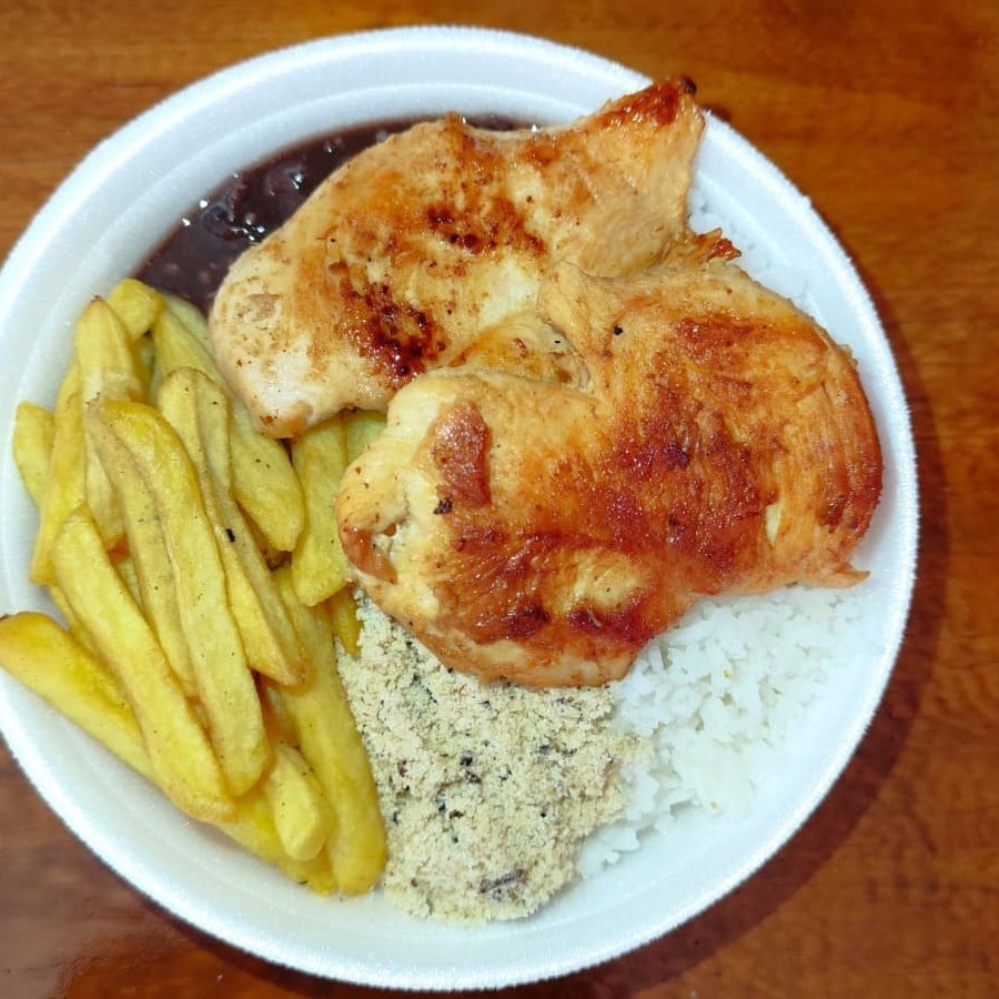 Refeição completa com um toque especial! Filé de frango grelhado no ponto certo, suculento e bem temperado, acompanhado de arroz branco soltinho, feijão preto caseiro, farofa crocante da casa e uma porção Grátis de batatas fritas douradas e fresquinhas. Tudo isso em uma marmita com cerca de 750g, ideal para matar a fome com muito sabor! Uma das favoritas do nosso cardápio.