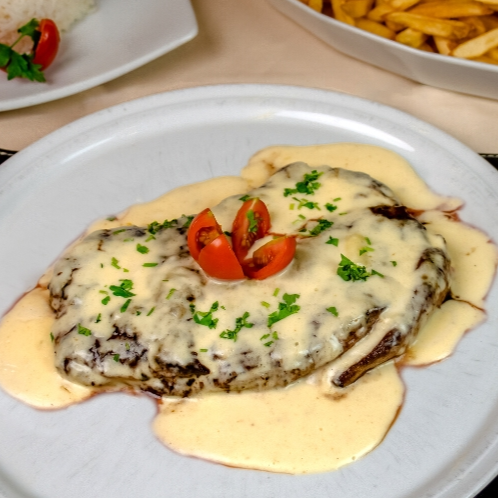 Bife de contra filé empanado ao molho branco por cima, finalizado com  uma cobertura de queijo mussarela derretido.  Marmita composta por arroz branco, feijão preto, farofa da casa, mais um acompanhamento a escolher.