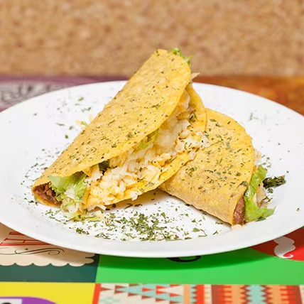 2 unidades de crocantes tortillas de milhos recheadas com frijoles refritos, guacamole, alface e queijo mix.