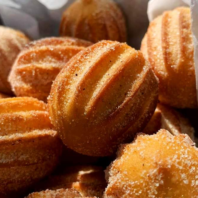 25 mini Churros fritos recheados de doce de leite e polvilhado com açúcar e canela.