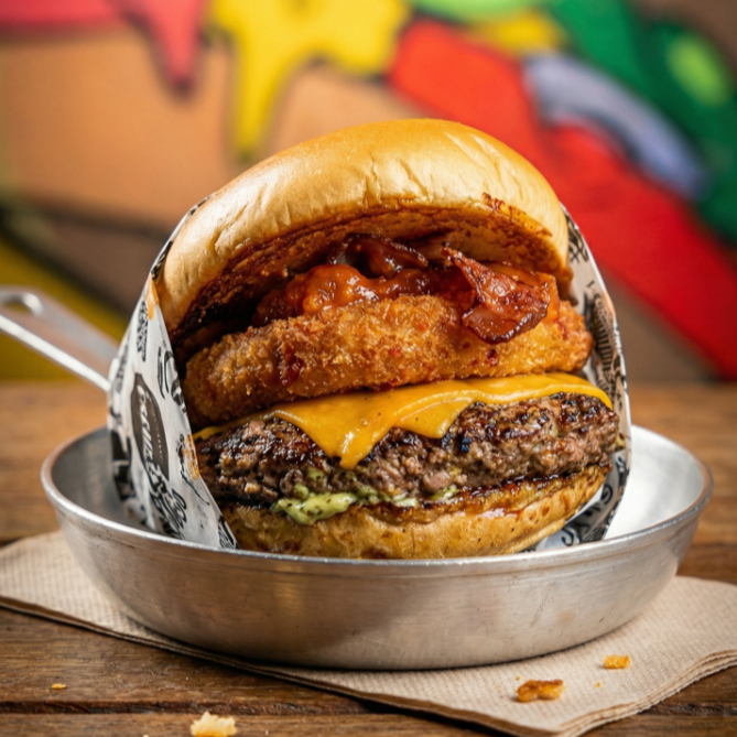 Pão brioche tostado na chapa, hambúrguer 160g, duas fatias de queijo cheddar, mussarela empanada, bacon, sweet chilli e maionese da casa.