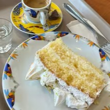 Fatia de Momo verão! Pão de ló branco, recheio de creme de limão e coberturas de recheio de coco e coco queimado.