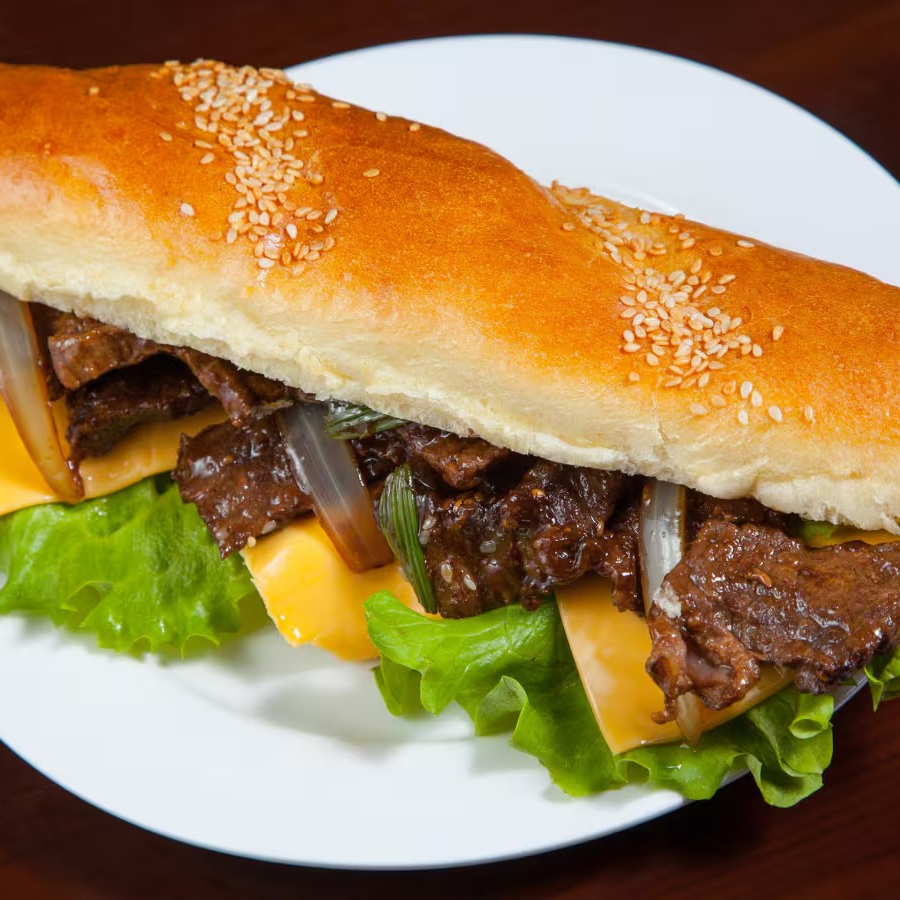 Lanche Irresistível com Contra Filé Suculento em Tiras, Queijo Prato, Molho de Alho, Cebola, Alface e Tomate na Baguete (25cm). Uma Pedida mais do que Perfeita!