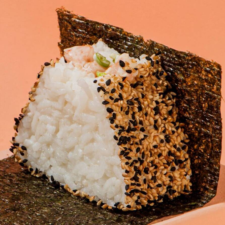 Bolinho de arroz Shari, recheado com camarão e maionese cítrica, feita com limão, hondashi, alho frito e cebolinha envolto por um mix de gergelim e acompanhado de alga nori, embalada separadamente para manter a crocância até o momento de consumo.