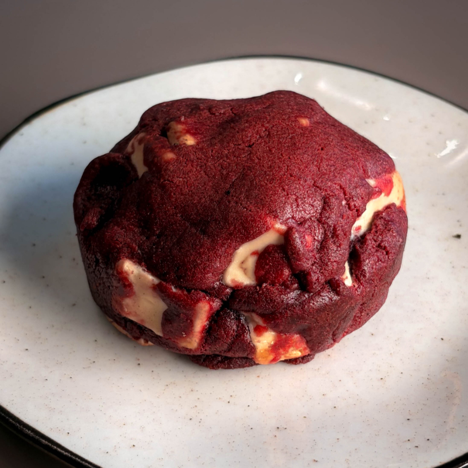 Nossa nova versão do Cookie Red Velvet. Com recheio delicioso de chocolate nobre branco. Ainda mais cremoso que antes. Chegará quentinho